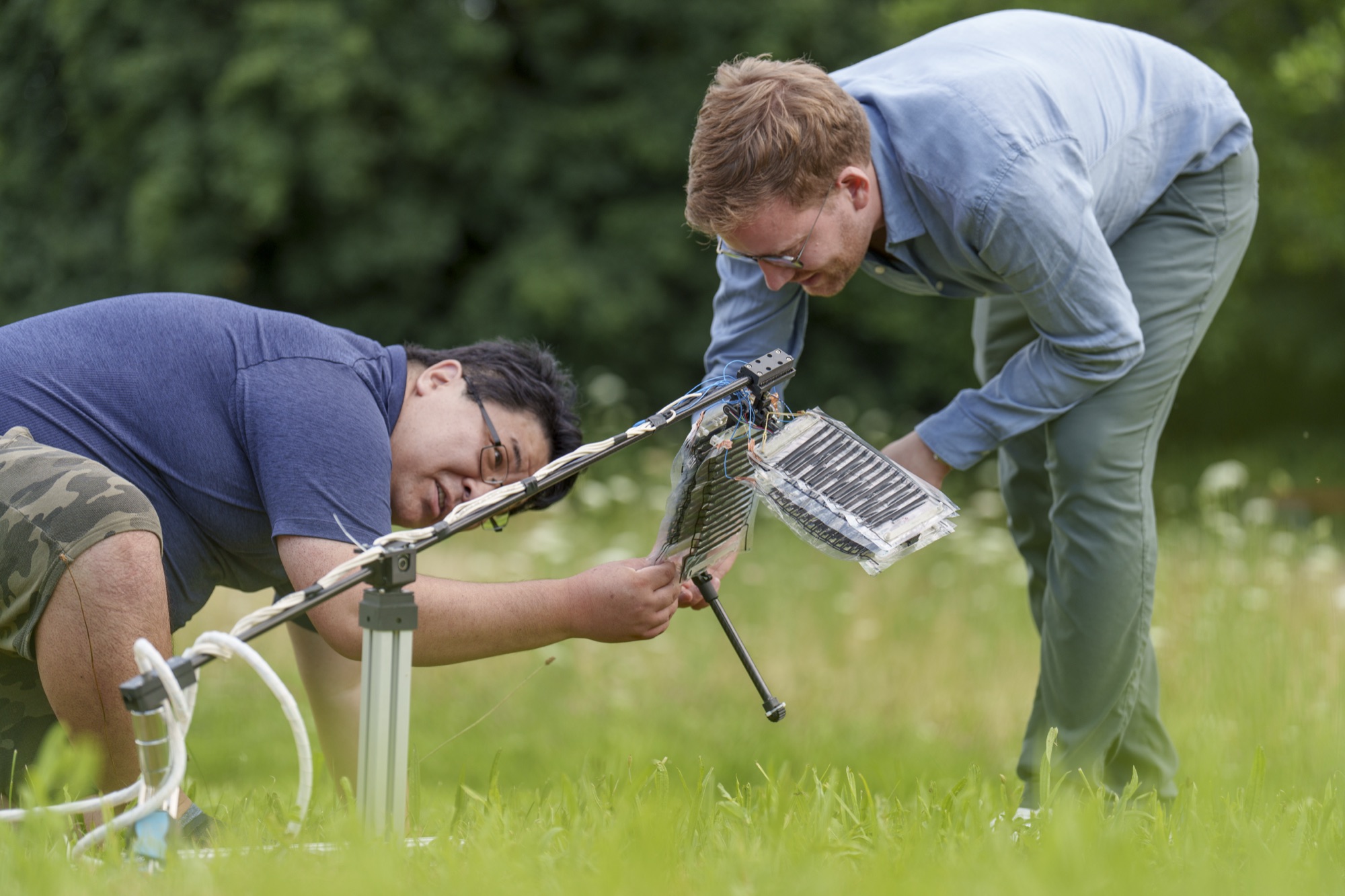 Researchers field-testing the robotic leg on grass